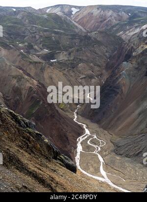 Creek eilt von schmelzenden Schneeflecken in Island herunter highlands Stockfoto