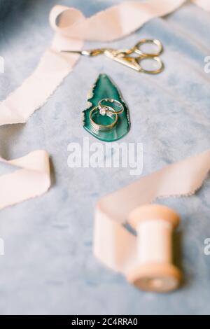 Diamantringe und Eheringe. Es gibt Seidenbänder herum. Stockfoto