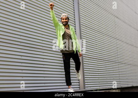 Junger Mann vor der Wellblechwand als Superman Stockfoto