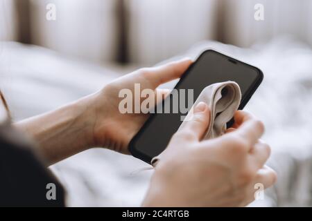 Reinigen des Smartphone-Bildschirms mit einem Glasfasertuch. Stockfoto