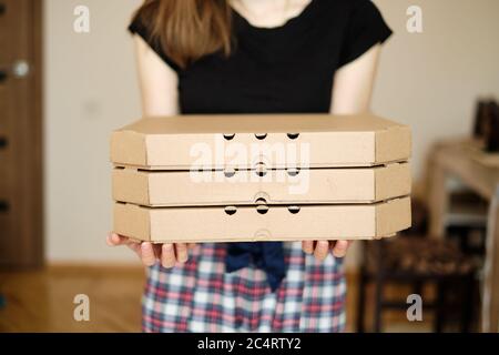Junge tausendjährige Frau hält Kisten mit leckeren Pizza zu Hause Stockfoto