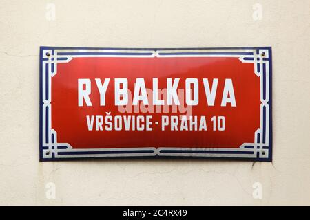 Rybalkova Straße. Traditionelle rote Straßenschild in Vršovice Bezirk in Prag, Tschechische Republik. Die Straße ist nach dem sowjetischen General Pawel Rybalko benannt, der Kommandant der 3. Garde Panzerarmee der 1. Ukrainischen Front der Roten Armee war, die an der Befreiung von Prag im Mai 1945 während des Zweiten Weltkriegs teilnahm Seine Panzertruppen gehörten zu den ersten Truppen der Roten Armee, die am Morgen des 9. Mai 1945 in Prag einmarschierten. Stockfoto