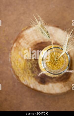 Kleine vermicelli in einem Glas auf einem hölzernen Ständer, auf dem Tisch verstreut Stockfoto