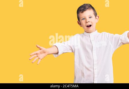 Cute blonde Kind trägt elegante Hemd lächelnd fröhlich bietet Hände geben Hilfe und Akzeptanz. Stockfoto