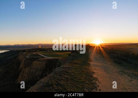 Hohe Hügel, die unter dem gelben Sonnenuntergang glänzen Stockfoto
