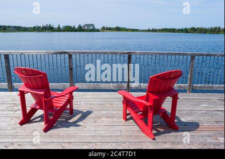 Zwei rote Stühle auf einer Aussichtsplattform mit Blick auf den Dalvay-See und das Dalvay-by-the-Sea Hotel. Prince Edward Island National Park, Kanada. Stockfoto