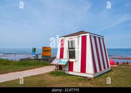 Rettungsschwimmerstation in der Nähe eines belebten Strandes. Promenade und Warnschilder. Blauer Himmel und ruhiges Wasser. Stanhope Beach, Prince Edward Island National Park, Kanada Stockfoto