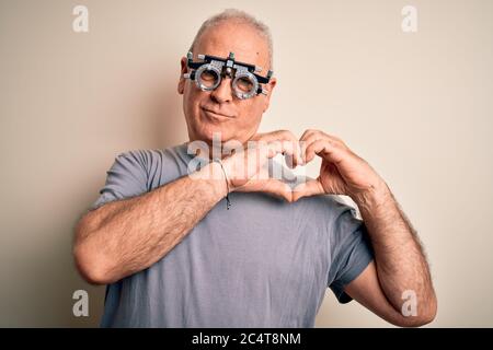 Mittelalter hory Mann Kontrolle Vision trägt Optometrie Brille auf weißem Hintergrund lächelnd in der Liebe zeigt Herz Symbol und Form mit Händen. Rom Stockfoto