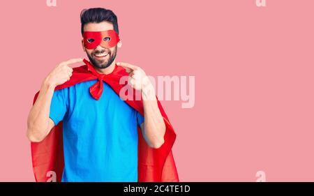 Junge gutaussehende Mann mit Bart trägt Superhelden Kostüm lächelnd fröhlich zeigen und zeigen mit Fingern Zähne und Mund. Zahngesundheit Konzept. Stockfoto