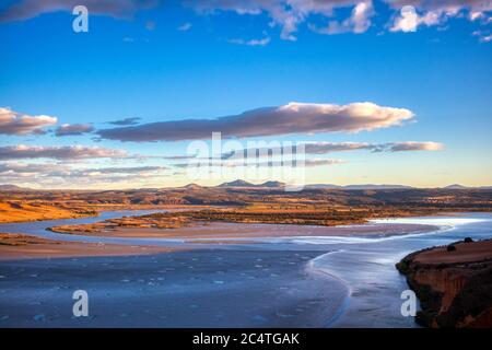 Berge, die unter dem wunderschönen blauen, wolkigen Himmel glänzen Stockfoto