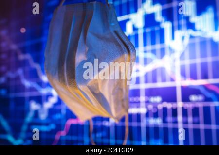 Medizinische Schutzmaske und Falling Stock Charts. Stockfoto