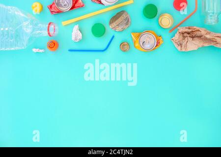 Recycelbarer verschiedenfarbiger Müll bestehend aus Papier, Glas, Metall, Kunststoff auf blauem Hintergrund. Abfalltrennungskonzept. Flatlay, Kopierplatz. Stockfoto