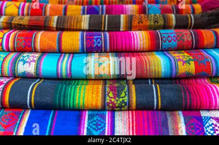 Die traditionellen andinen Stoffe, die auf dem Handwerksmarkt in Otavalo, Ecuador, verkauft werden. Stockfoto