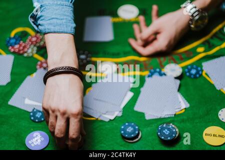 Croupier hält Spielkarten, Spielchips auf dem Tisch. Stockfoto