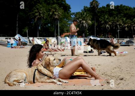 Peking, Portugal. Juni 2020. Am 28. Juni 2020 genießen die Menschen die Freizeit mit ihren Hunden an einem haustierfreundlichen Strand in Oeiras, Portugal. Quelle: Pedro Fiuza/Xinhua/Alamy Live News Stockfoto