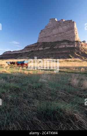 Überdachte Waggons im Mock unter dem Scotts Bluff National Monument entlang des berühmten Oregon Trail im Westen Nebraskas Stockfoto