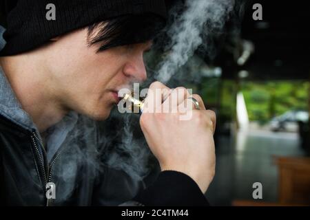 Nahaufnahme eines jungen Mannes, der einen Dampf dampft Stockfoto