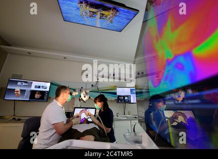 Dresden, Deutschland. Juni 2020. ILLUSTRATION - Zahnarzt Conrad Kühnöl (l) und ein Dentalhygieniker untersuchen einen Patienten mit einem Fluoreszenzmikroskop in der Zahnarztpraxis. (Posed Scene) (to dpa 'mit High-Tech aus Corona-Krise: Dresdner Zahnarzt setzt auf Digital') Quelle: Robert Michael/dpa-Zentralbild/dpa/Alamy Live News Stockfoto