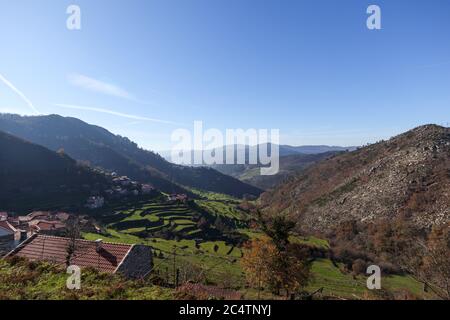 Hohe Berge mit Grün bedeckt, die unter dem blauen Himmel glänzen Stockfoto