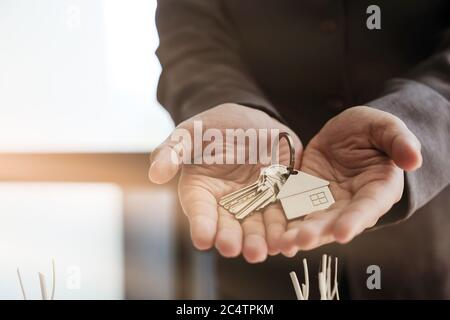 Immobilienmakler Übergabe Hausschlüssel mit genehmigten Hypothek Antragsformular und bieten Handschlag Stockfoto