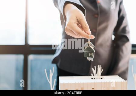 Immobilienmakler, der den Hausschlüssel für den Kunden übergibt Stockfoto