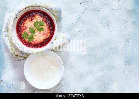 Köstliche und lebendige, kinderfreundliche Suppe aus roher Rote Bete, Karotte und Kartoffeln, garniert mit Creme fraiche und zerbröseltem Feta-Käse Stockfoto