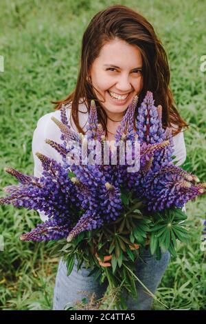 Frau auf blühenden Lupinen Feld Stockfoto