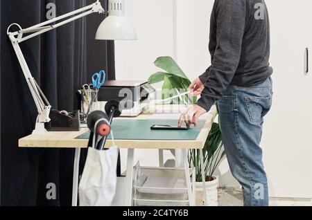 Männlicher Mitarbeiter, der Dokumente auf dem Schreibtisch druckt Stockfoto