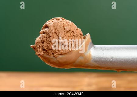 Seitenansicht Löffel, der eine Eiscreme aus einer Schachtel mit Schokoladeneis herausnimmt Stockfoto