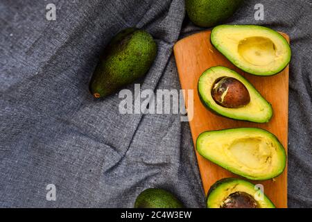 Avocado auf einem Holzbrett. Gesundes Lebensmittelkonzept. Draufsicht, Kopierbereich Stockfoto