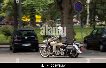 Belgrad, Serbien - 25. Juni 2020: Reifer Mann in Lederjacke auf einem Doppelsitz Motorrad mit Seitentaschen auf der Straße der Stadt Verkehr, Seite hinten Stockfoto