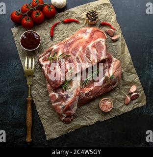 Rack von rohen Schweinefleisch Spare Rippen gewürzt auf einem zerknitterten Papier Stockfoto