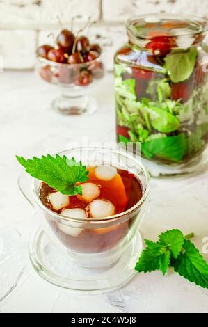 Glas Tasse und eine große Kanne eisigen Sommer Minztee. Konzept der Kühle im heißen Sommer. Stockfoto