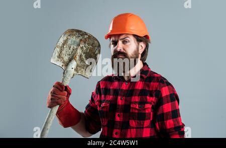 Bauarbeiter in Hut. Ingenieur Architekt in Schutzhelm. Brutaler Techniker Baumeister. Fabrikarbeiter Mechaniker. Industriearbeiter in Helm. Mann halten Schaufel in Handschuhen. Stockfoto