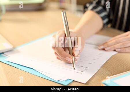 Nahaufnahme der Frau Hände Ausfüllen Antragsformular sitzt auf einem Schreibtisch zu Hause Stockfoto