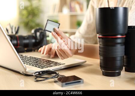 Nahaufnahme einer Fotografin Frau Hände zeigen Speicherkarte mit Laptop zu Hause Stockfoto