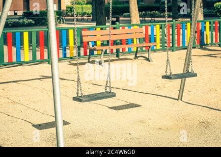 Kinderspielplatz mit leeren Schaukeln, die mit Stahlketten aufgehängt sind Stockfoto