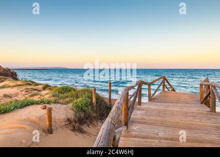 Landschaft des Guardamar Strandes mit Holzzugang durch die Dünen Stockfoto