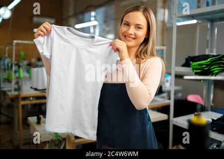 Nette Frau Schneider hält gerade genäht T-Shirt Stockfoto