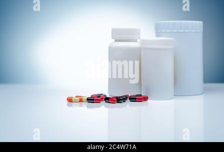 Antibiotika-Kapsel Pillen und leere Etikett Kunststoff-Drogenflasche auf Gradienten Hintergrund. Pharmaindustrie. Antibiotikaresistenz. Antibiotika. Stockfoto