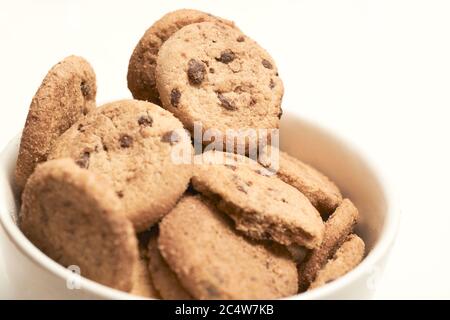 Selektive Fokus Schuss von Chocolate Chip Cookies in einem weißen Schale mit weißem Hintergrund Stockfoto