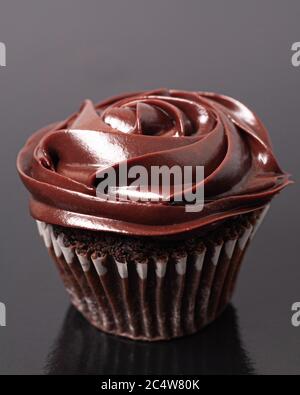 Vertikale selektive Fokusaufnahme eines Schokoladen-Cupcake mit einem Schokoladenfrosting Stockfoto