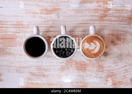 High-Angle-Aufnahme von drei Tassen verschiedenen Kaffee auf Eine hölzerne Oberfläche Stockfoto