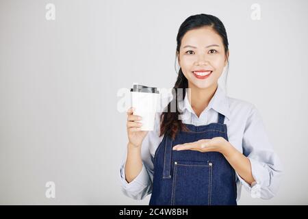Porträt der lächelnden jungen weiblichen Coffeeshop Besitzer zeigt Tasse oder nehmen Kaffee sie für Kunden gemacht Stockfoto