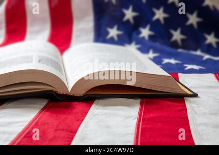 Buch geöffnet auf USA Flagge Hintergrund, Nahaufnahme. Vereinigte Staaten von Amerika Bildung, Kultur, Religion Konzept Stockfoto