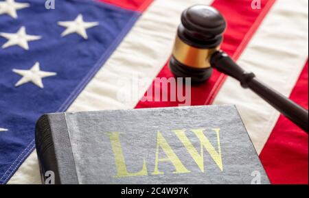 Gesetzentext auf schwarzem Buch und Richter gavel auf US-amerikanische Flagge Hintergrund. Gerechtigkeit in den USA Konzept Stockfoto