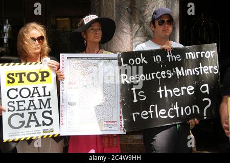 Demonstranten gegen CSG halten Schilder vor dem Sheraton on the Park Hotel in Sydney. Stockfoto