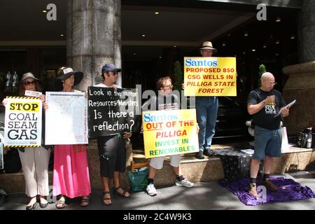 Ein Redner spricht die Kundgebung an, während die Demonstranten gegen vorgeschlagene CSG-Brunnen im Pilliga State Forest Schilder halten. Stockfoto