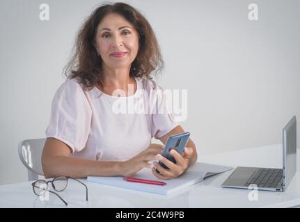 Innenportrait einer schönen lächelnden älteren Frau, die bei arbeitet Zu Hause Stockfoto
