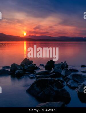 Sonnenuntergang über dem Windermere See mit Blick über das Wasser zu den Langdales Stockfoto